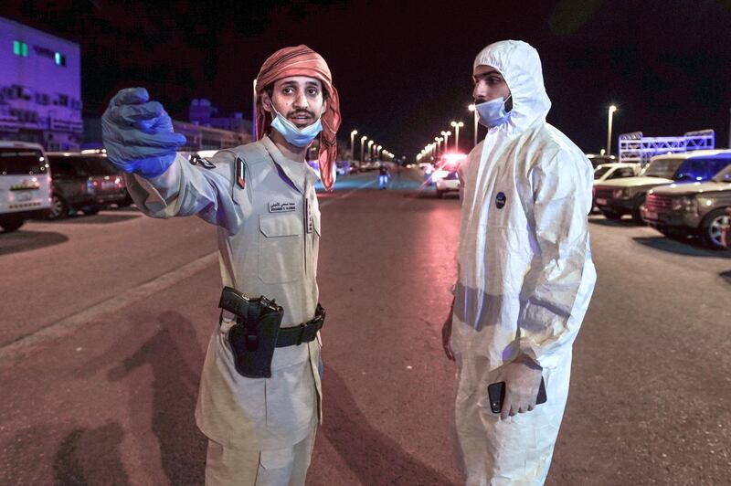 Abu Dhabi, United Arab Emirates, April 14, 2020.   Abu Dhabi Civil Defence and Police sterilisation drive in Mussafah.   
  --Mohammed Al Ahbabi (left) one of the Abu Dhabi Police Captain's who led the sterilisation drive, coordinates with a First Rsponder team member of the Abu Dhabi Civil Defence.
Victor Besa / The National
Section:  NA
Reporter:  Haneen Dajani