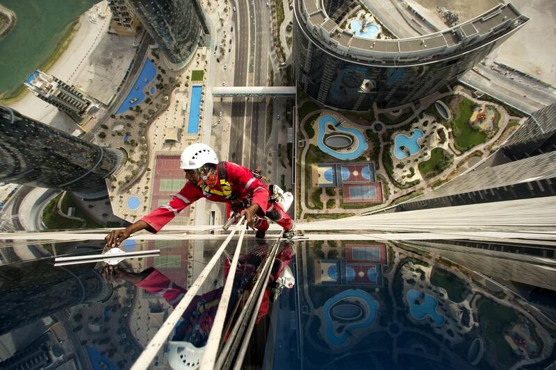 Workers wash windows at Gate Towers on Reem Island in Abu Dhabi. Christopher Pike / The National