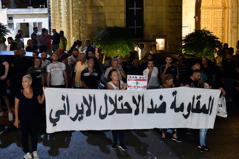 People carry a banner that reads in Arabic 'The resistance against the Iranian occupation'. EPA