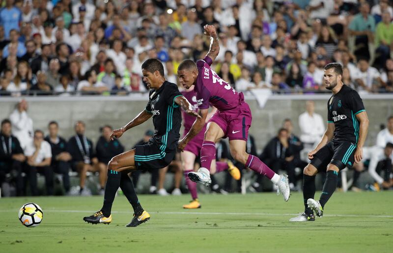 Manchester City's Gabriel Jesus, centre, shoots under pressure from Real Madrid's Raphael Varane. Jae C Hong / AP Photo