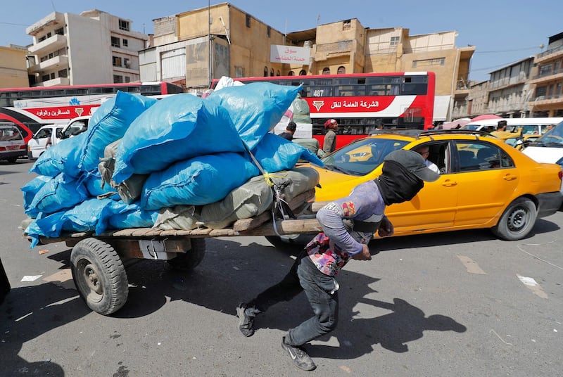 A porter pulls a laden handcart at Tahrir Square market in Baghdad. AFP