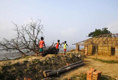 In this photo taken on May 18, 2019, Indian children play on the coast affected by erosion on the Ghoramara island around 110 km south of Kolkata, ahead of the 7th and final phase of India's general election. Thousands of former Ghoramara residents have already moved to Sagar, a bigger island in the delta, or moved to Kakdwip on the mainland in the last few years. Roughly half of the island has disappeared to rising water levels, erosion and changing weather patterns of the eco-sensitive delta zone in the last three decades. - To go with story 'INDIA-VOTING-ELECTION-ENVIRONMENT-CLIMATE' by Bhuvan Bagga
 / AFP / DIBYANGSHU SARKAR / To go with story 'INDIA-VOTING-ELECTION-ENVIRONMENT-CLIMATE' by Bhuvan Bagga
