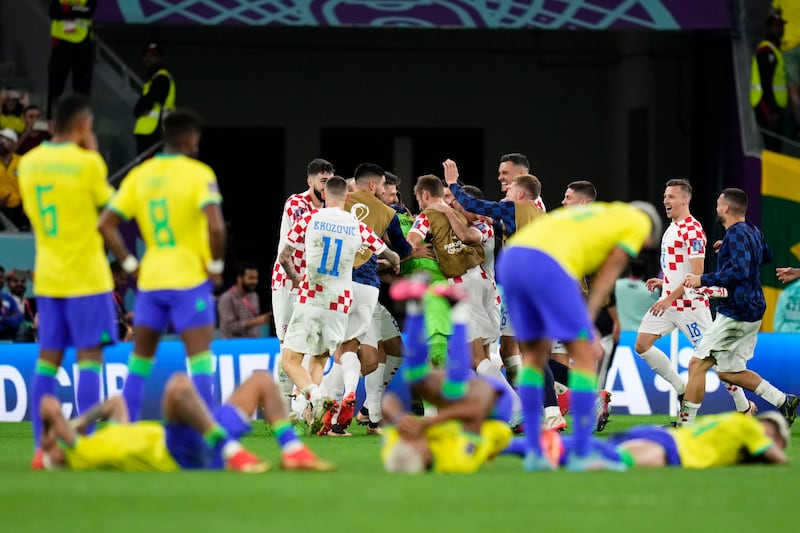 Croatia players celebrate victory while Brazil players react to the defeat. AP