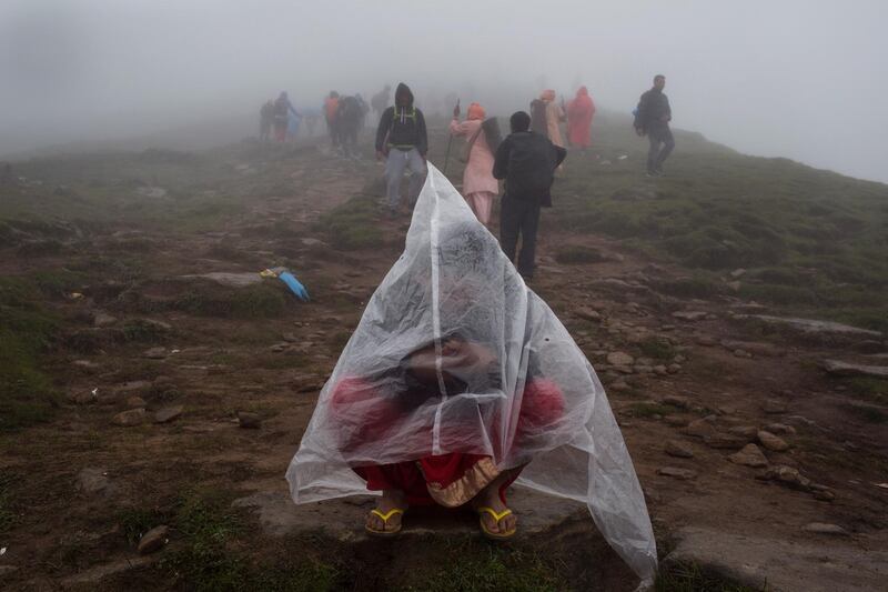 A devotee wears a plastic cape during a summer rain shower while trekking to reach Gosaikunda Lake. Narendra Shrestha/EPA