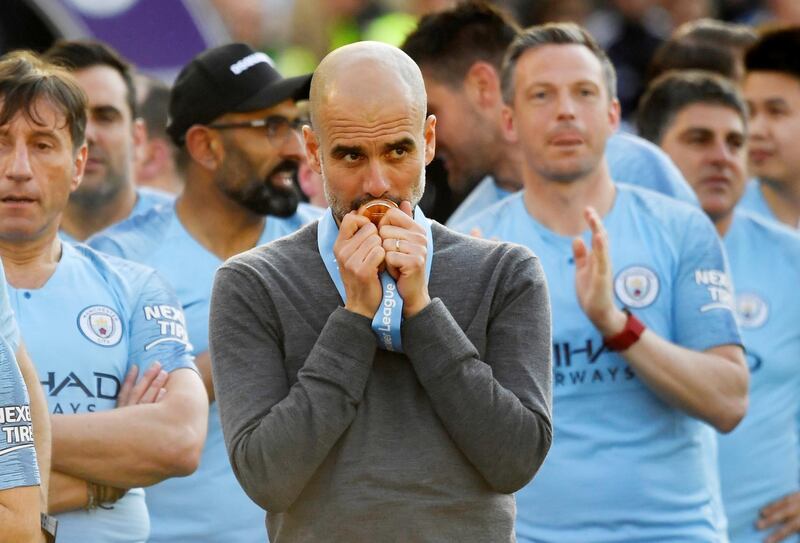 Manchester City manager Pep Guardiola kisses his medal as he celebrates winning the Premier League title. Reuters
