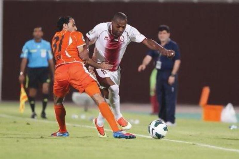 Al Wahda’s Marcelo Oliveira Da Silva, right, gets past Ajman’s Jasem Ali Mohamed on Friday night. Mustafa Raza / Al Ittihad