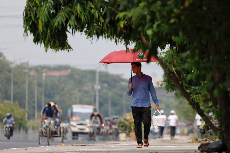 A man uses an umbrella to protect himself from the sun during a heatwave in Dhaka, Bangladesh, on Sunday. Reuters