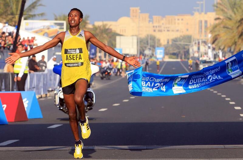 Ethiopian runner Tsegaye Mekonnen Asefa crosses the finish line first at the Standard Chartered Dubai Marathon on Friday. AP Photo