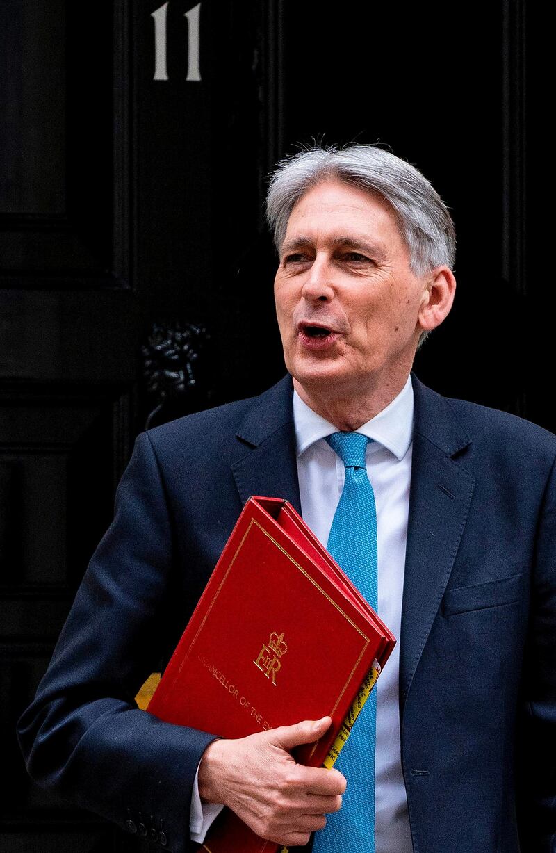 Britain's Chancellor of the Exchequer Philip Hammond leaves from 11 Downing Street in central London on March 13, 2019, headed for the Houses of Parliament where he is set to deliver his Spring Budget update. British MPs will vote Wednesday on whether the country should leave the EU without a deal in just over two weeks, after overwhelmingly rejecting a draft divorce agreement. The House of Commons is expected to vote against a "no deal" Brexit, although this could still happen on March 29 unless it can agree on what should happen instead. / AFP / Niklas HALLE'N
