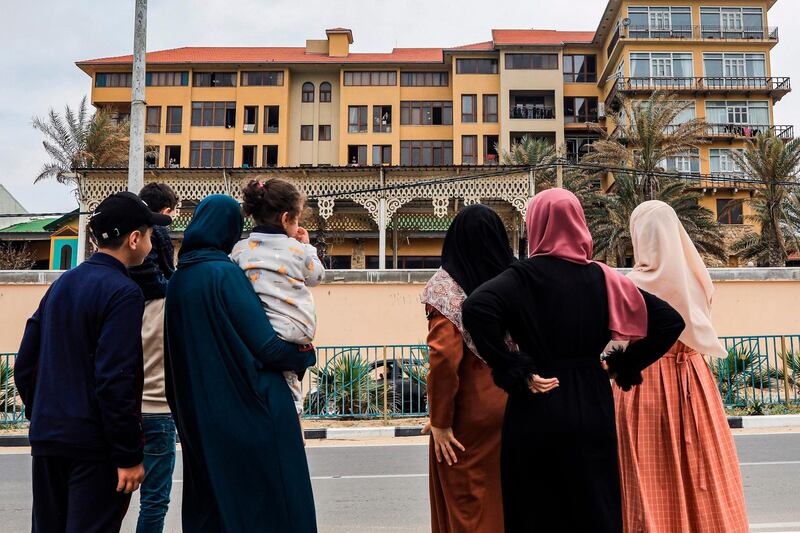 Members of a Palestinian family look at Al Mathaf hotel, where their relatives are quarantined, to limit the spread of the coronavirus pandemic, in Gaza City. AFP