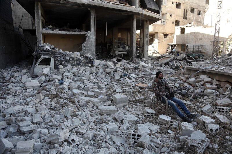 A Syrian man sits amidst the destruction in the rebel-held town of Hamouria, in the besieged Eastern Ghouta region on the outskirts of the capital Damascus, on March 9, 2018. / AFP PHOTO / ABDULMONAM EASSA