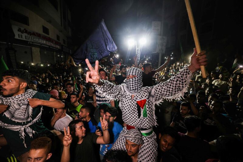 Palestinians celebrate in the streets following a ceasefire brokered by Egypt between Israel and the ruling Islamist movement Hamas. Mohammed Abed / AFP