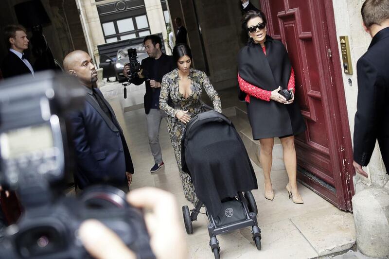 Kim Kardashian, centre, pushes a stroller next to her partner Kanye West, left, and her mother Kris Jenner, right, as they leave their hotel on May 23, 2014 in Paris. Kenzo Tribouillard / AFP photo