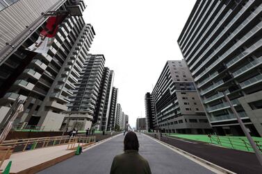 (FILES) In this file photo taken on June 20, 2021, a reporter looks at the buildings which will host the athletes during the 2020 Tokyo Olympic Games, during a media tour of the Olympic Village in Tokyo.  - For athletes competing at the Tokyo Games, the Olympic Village will be almost all they see, with strict coronavirus rules preventing them from leaving the compound except to train and compete.  (Photo by Behrouz MEHRI  /  AFP)  /  TO GO WITH Oly-2020-2021-Japan-health-virus-Village,FOCUS by Etienne Balmer