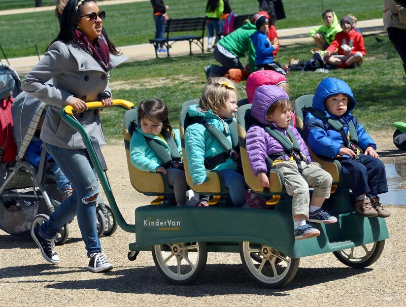 WASHINGTON, D.C. - APRIL 20, 2018:  A daycare center employee pushes a KinderVan filled with preschool children on an outing along the National Mall in Washington, D.C. (Photo by Robert Alexander/Getty Images)