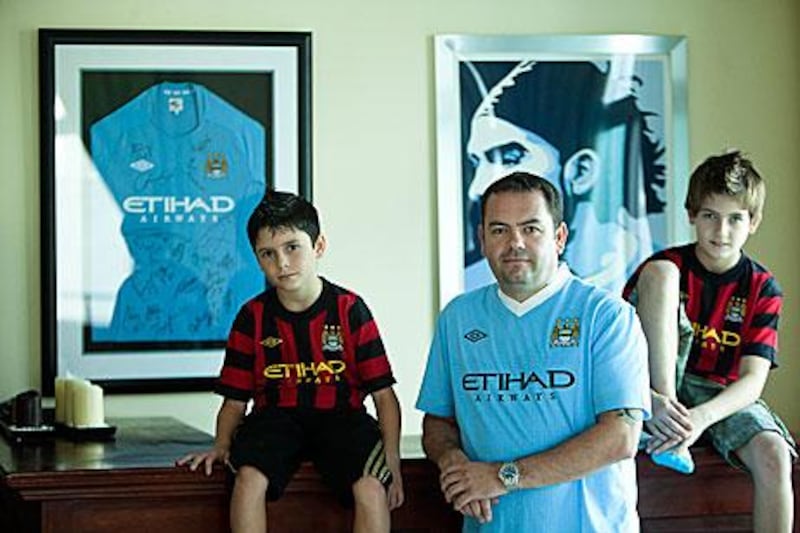 Darren Ball, centre, and his sons, Aidan, left, and Declan, are huge Manchester City fans.