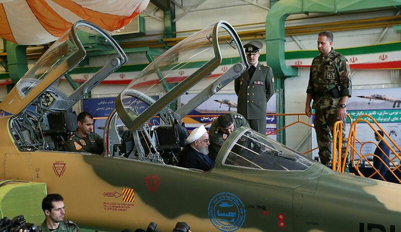 A handout picture released by the Iranian Presidency on August 21, 2018, shows President Hassan Rouhani waiving to pilots sitting in the cockpit of the "Kowsar" domestic fighter jet, a fourth-generation fighter, with "advanced avionics" and multi-purpose radar, which the local Tasnim news agency said was "100-percent indigenously made". - Iran unveiled its first domestic fighter jet at a defence show in the capital Tehran today. (Photo by HO / Iranian Presidency / AFP)