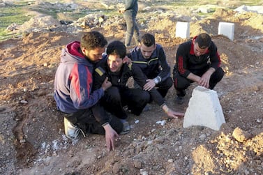 IDLIB, SYRIA - APRIL 6: Abdel Hameed Alyousef (2nd L) mourns over his wife and twin babies, killed in the chemical attack by Assad Regime, at their cemetery in Idlib, Syria on April 6, 2017. Abdel Hameed Alyousef lost his wife and 9 month old twin babies named Aya and Ahmad in addition to 13 of his family members in the chemical attack. The grief-stricken father said: " Dear God took Ahmad and Aya, I am not upset over this. Gulf countries do not deliver an international society which they speak of. We will be patient until the last day and the victory will come. We are not the first nor the last. Our children have been dying in our hands for 6 years. No one seems to help." Assad Regime struck Khan Shaykhun district of Idlib in Syria with a chemical weapon leaving at least 100 civilians, including women and children, dead and at 500 affected from the gas. (Photo by Mohammed Al Daher/Anadolu Agency/Getty Images)