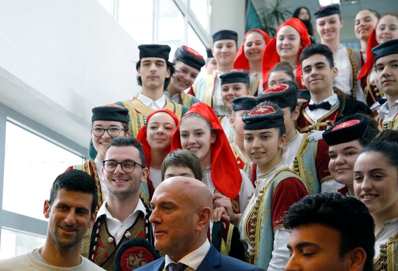 Novak Djokovic, bottom left, poses with local official Marko Carevic, bottom center, and children in Budva, Montenegro. AP