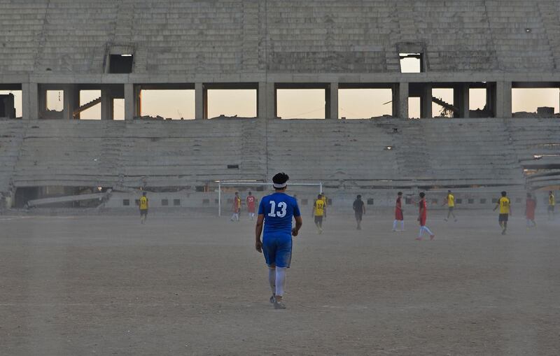 Players of Al Mosul FC practise at the ravaged Al Idara Al Mahalia stadium, which was once used by ISIS as a weapons depot, near the northern Iraqi city of Mosul. AFP