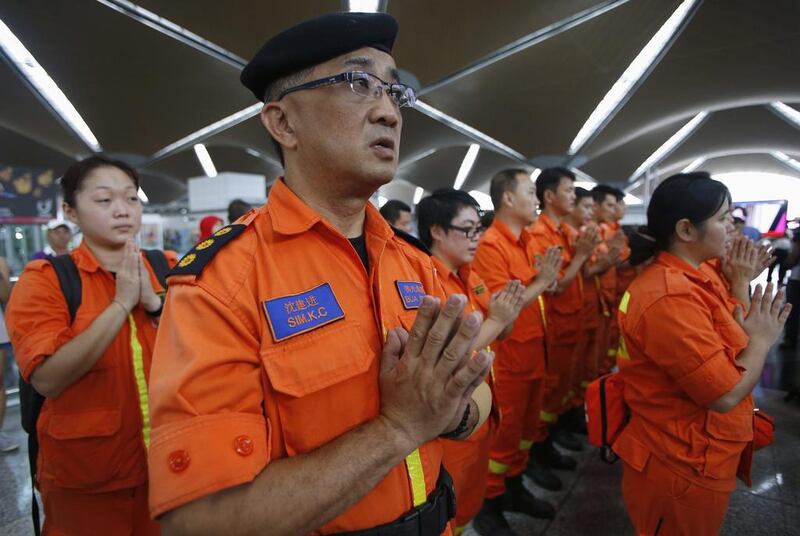 Rescue workers from a Buddhist organisation pray during multi-religion mass prayers for the passengers of Malaysian Airlines flight MH370. Edgar Su / Reuters