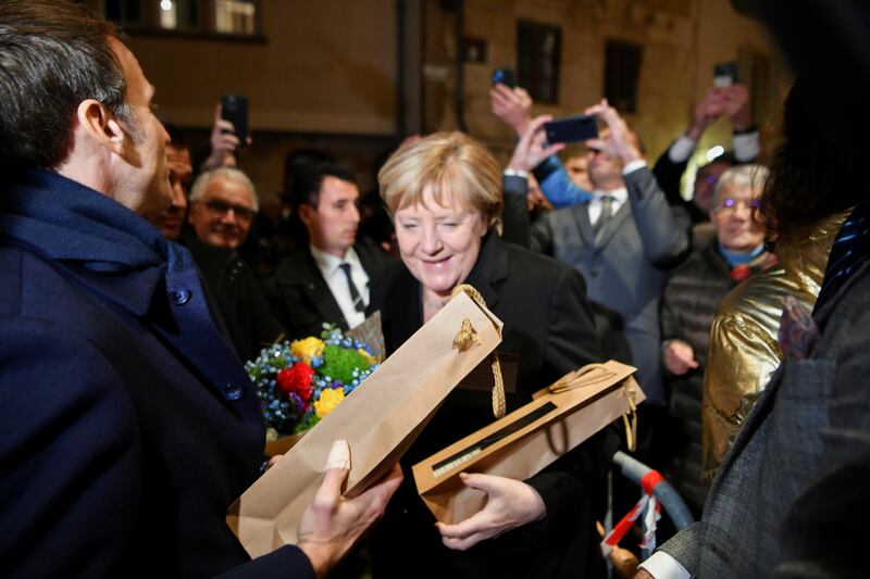 Angela Merkel and Emmanuel Macron receive flowers and gifts upon their arrival. Reuters
