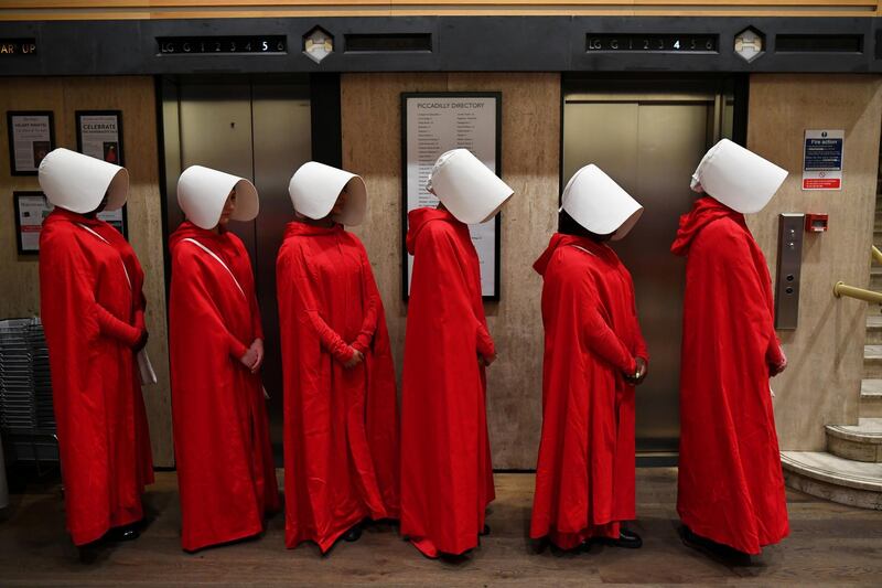 People dressed up as characters from Margaret Atwood's "The Handmaid's Tale" queue to get a copy of her new novel "The Testaments" at Waterstones bookshop in London, Britain.  Reuters