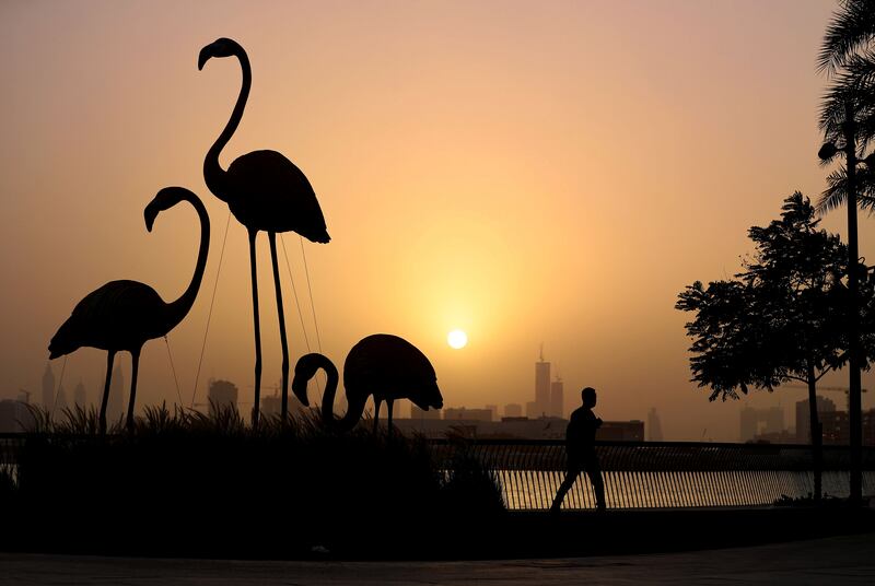 Visitors to Dubai Creek Harbour enjoy the sunset on the longest day of the year in Dubai. Chris Whiteoak / The National