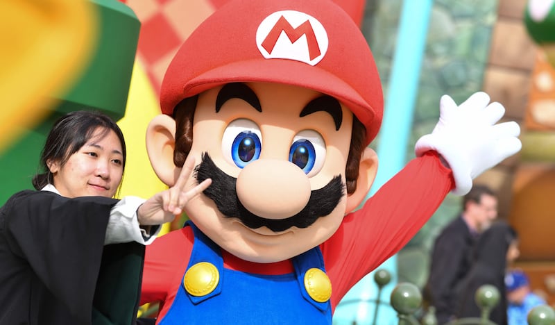 A guest takes a photo with Mario during a preview of Super Nintendo World at Universal Studios in Los Angeles, California, on January 13, 2023.  - Nintendo's first theme park outside of its native Japan will open in California next month, just weeks before Mario gets the big-screen treatment in a major new Hollywood film.  "Super Nintendo World" will be part of Universal Studios Hollywood -- an amusement park which is traditionally home to rides based on film and TV franchises from "Waterworld" to Harry Potter.  (Photo by Chris Delmas  /  AFP)