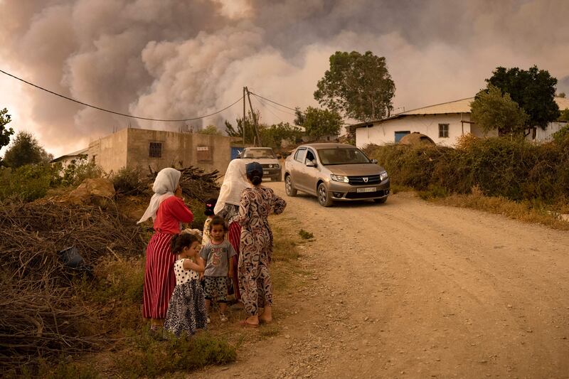 Villagers stand by the roadside as a wildfire sweeps through a forest in Morocco in August. Extreme weather conditions are becoming the 'new norm', say UN weather experts. AFP