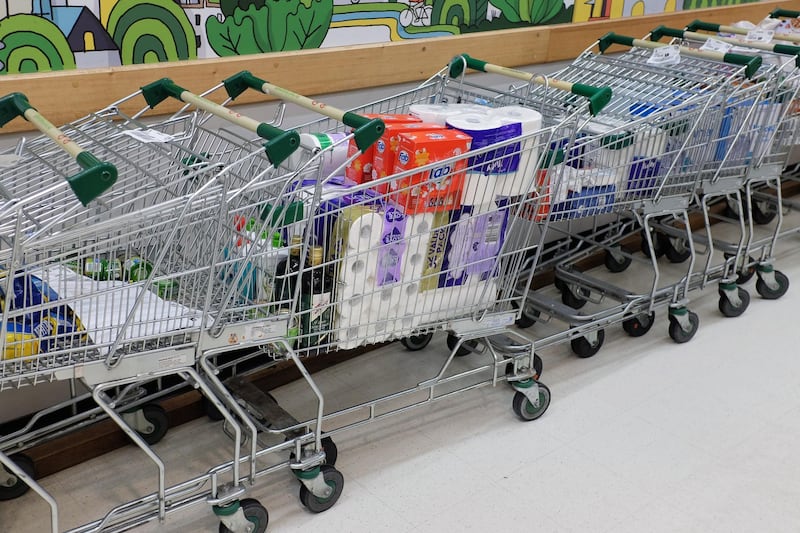 A shopping cart filled with toilet paper, kitchen paper and other products stands inside a supermarket in Sydney, Australia. Bloomberg