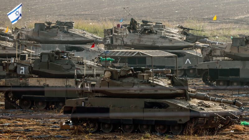 Israeli soldiers and armoured vehicles are gathered at an undisclosed location near the border with Gaza on Sunday. EPA