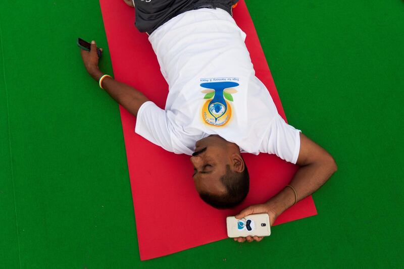 A practitioner rests on his mat as he takes part in a mass yoga session on International Yoga Day at Rajpath in New Delhi. Xavier Galiana / AFP