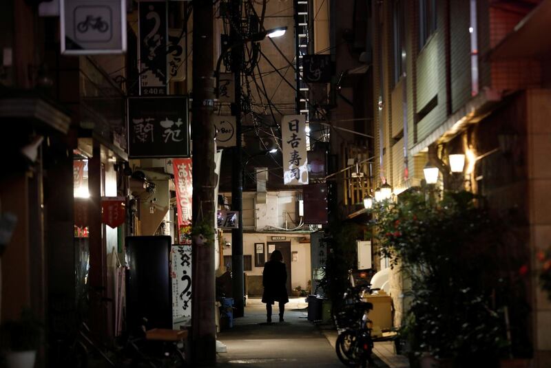 A man walks past restaurants which closed after 8pm, the time the government asks them to close by, amid the coronavirus emergency decree in Tokyo, Japan. Reuters