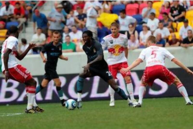 Manchester City's Emmanuel Adebayor takes on the New York Red Bulls defence in an exhibition game in 2010. Sharon Latham / PA