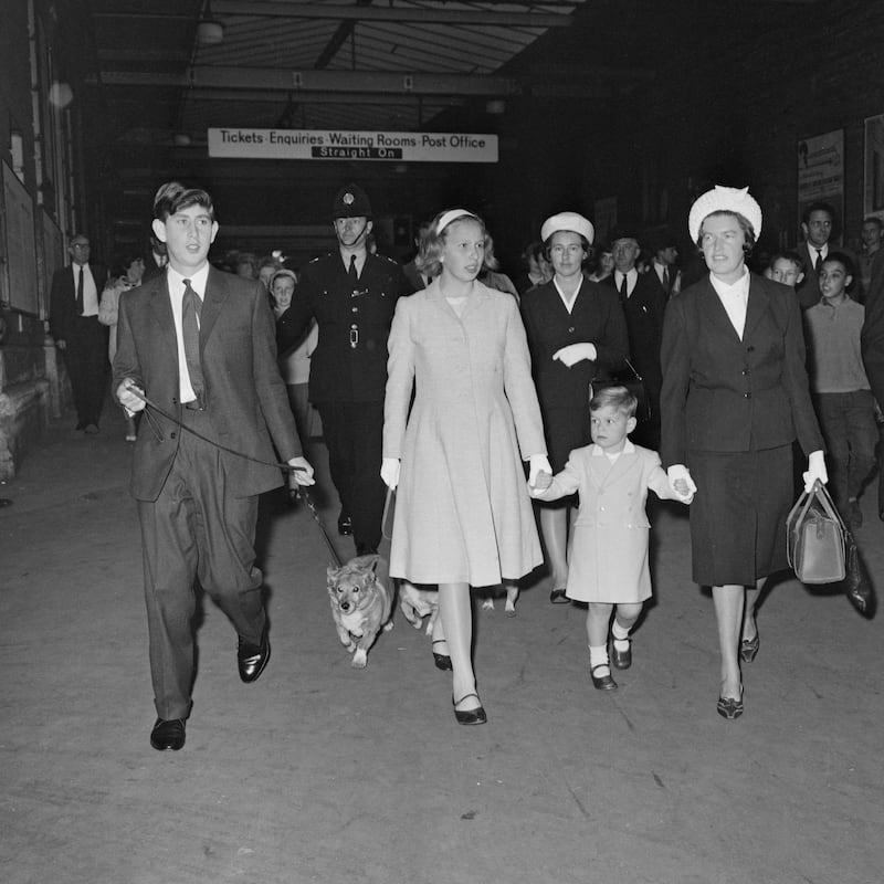 Prince Charles, walking a Corgi, Princess Anne, Prince Andrew and their nanny Mabel Anderson at Euston Station, London, in 1963