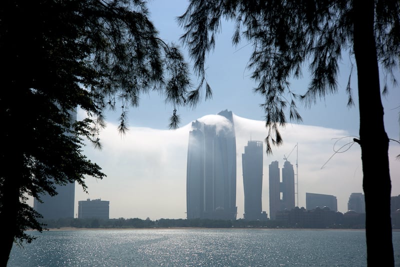 November 23, 2014 -- The last of an early morning fog bank wraps around skyscrapers in Abu Dhabi as the sun burns off the fog. Seen in this photo is Etihad Towers (center). (Brian Kerrigan / The National)