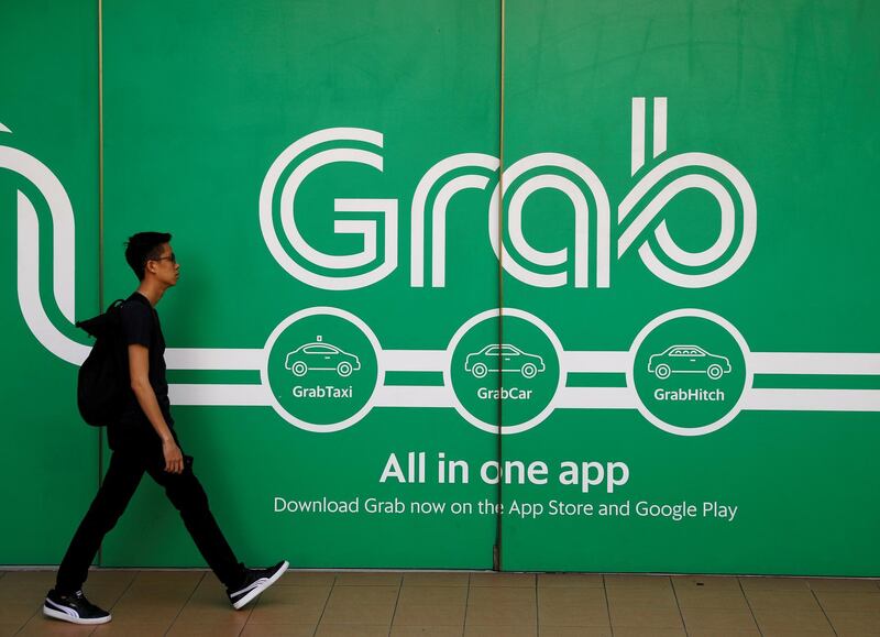 FILE PHOTO: A man walks past a Grab office in Singapore March 26, 2018. REUTERS/Edgar Su/File Photo