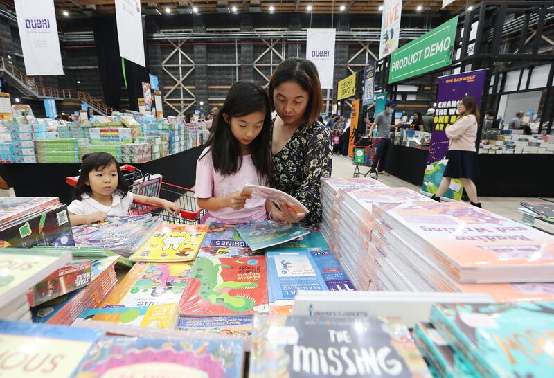 Mei, centre, with her mother Yu browsing the selection of books at The Big Bad Wolf Book Fair in Dubai Studio City. All photos: Chris Whiteoak / The National
