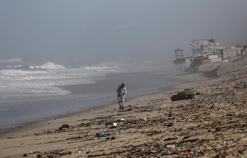 epaselect epa07292996 A Hamas security inspects the wreckage of an Egyptian fishermen's boat which was destroyed on a beach in southern Gaza Strip, 17 January 2019. According to reports, Hamas Civil defense team rescused six Egyptian fishermen and one still missing at the sea after their boat crashed due to weather conditions.  EPA/MOHAMMED SABER