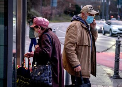 Two elderly people in face masks stand near an elevator during the coronavirus pandemic in Frankfurt, Germany, Thursday, Jan. 14, 2021. (AP Photo/Michael Probst)