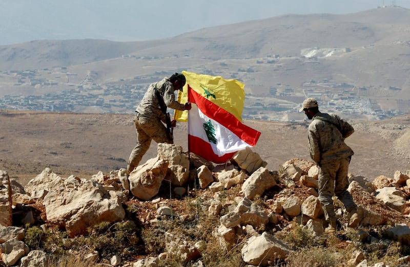 FILE PHOTO: Hezbollah fighters put Lebanese and Hezbollah flags at Juroud Arsal, Syria-Lebanon border, July 25, 2017. REUTERS/Mohamed Azakir/File Photo