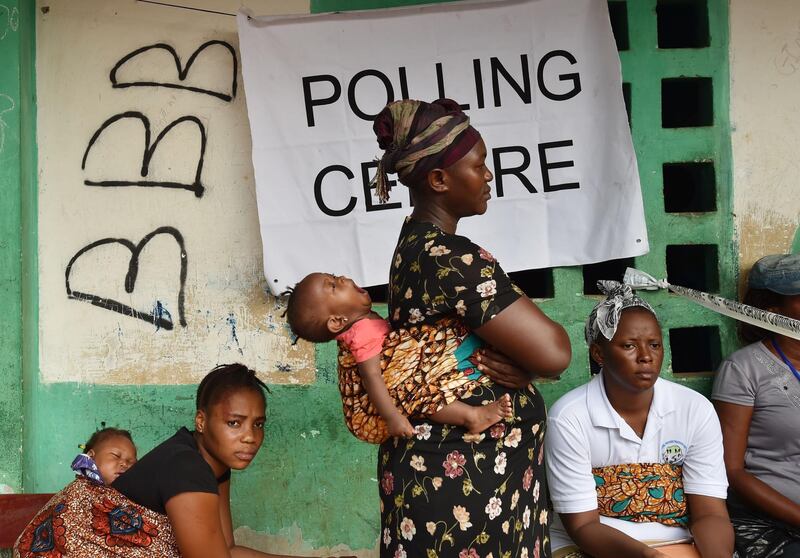 People wait outside a polling station to cast their vote during the country's general elections in Freetown on March 7, 2018.
More than 3.1 million voters are registered for the polls across the small West African nation. / AFP PHOTO / ISSOUF SANOGO