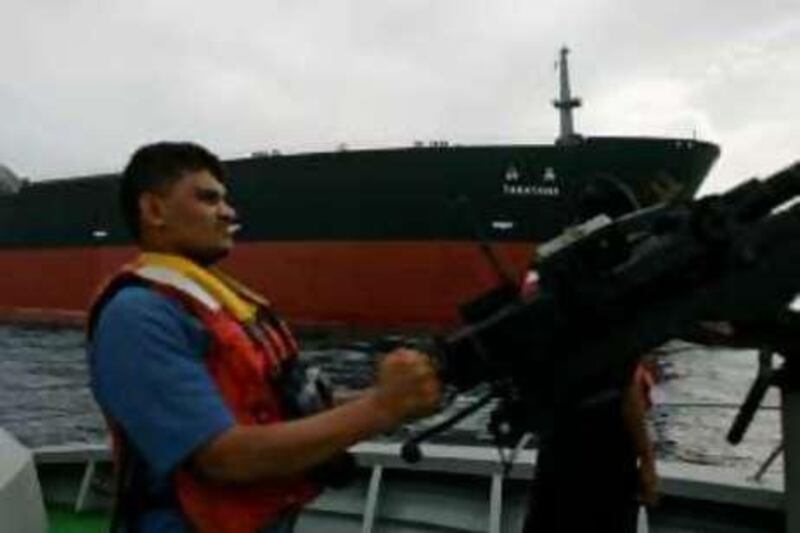 A Yemeni Coast Guard soldier is seen on a patrol boat near the Japanese oil tanker Takayama as it sails outside Yemen's southern port of Aden April 22, 2008. The ship was fired on in the Gulf of Aden, off Yemen on Monday, owner Nippon Yusen KK said, with Japanese media reporting the ship was hit by a rocket in the pirate-infested region. None of the 23 crew on board the Takayama were injured and the tanker was capable of continuing its voyage, Nippon Yusen spokesman Satoshi Yokoyama said. REUTERS/Khaled Abdullah (YEMEN)