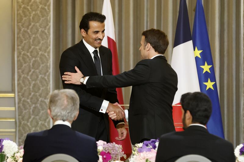 Mr Macron welcomes Sheikh Tamim to the reception. EPA