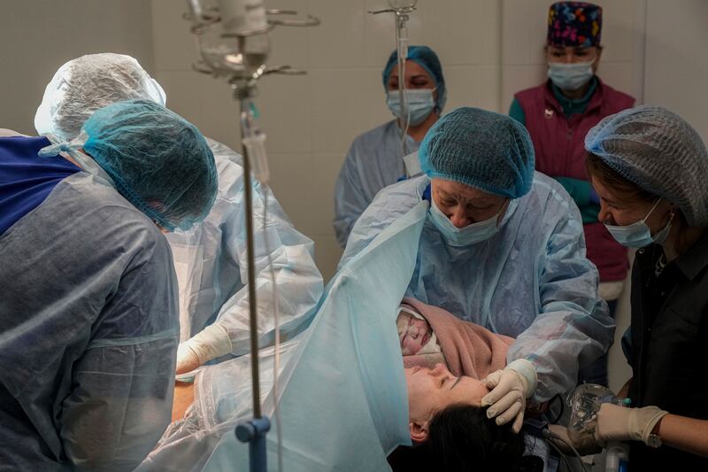 Medical workers hold newborn Alana close to her mother after a cesarean section at a hospital in Mariupol. AP Photo