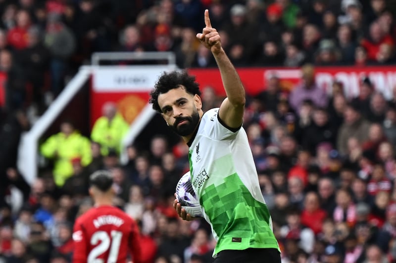 Liverpool's Egyptian striker #11 Mohamed Salah celebrates after scoring their second goal from the penalty spot during the English Premier League football match between Manchester United and Liverpool at Old Trafford in Manchester, north west England, on April 7, 2024.  (Photo by Paul ELLIS / AFP) / RESTRICTED TO EDITORIAL USE.  No use with unauthorized audio, video, data, fixture lists, club/league logos or 'live' services.  Online in-match use limited to 120 images.  An additional 40 images may be used in extra time.  No video emulation.  Social media in-match use limited to 120 images.  An additional 40 images may be used in extra time.  No use in betting publications, games or single club/league/player publications.   /  