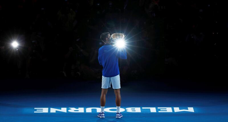 Novak Djokovic poses with the championship trophy. Reuters