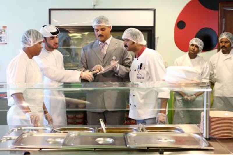 January 12, 2011 / Abu Dhabi / (Rich-Joseph Facun / The National) Ibrahim A. Al Ali , (CQ), an Inspector with the Abu Dhabi Food Control Authority, second from left, and Mansour A. Abd El Latif (CQ), center, a Senior Inspector with the Abu Dhabi Food Control Authority inspect the school cafeteria of the Emirates National School as part of an ongoing campaign, Wednesday, January 12, 2011 in Abu Dhabi. 