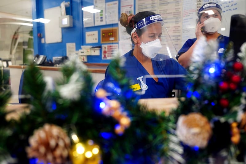 Nurses work at a desk surrounded by Christmas decorations in a ward for Covid-19 patients at King's College Hospital. PA